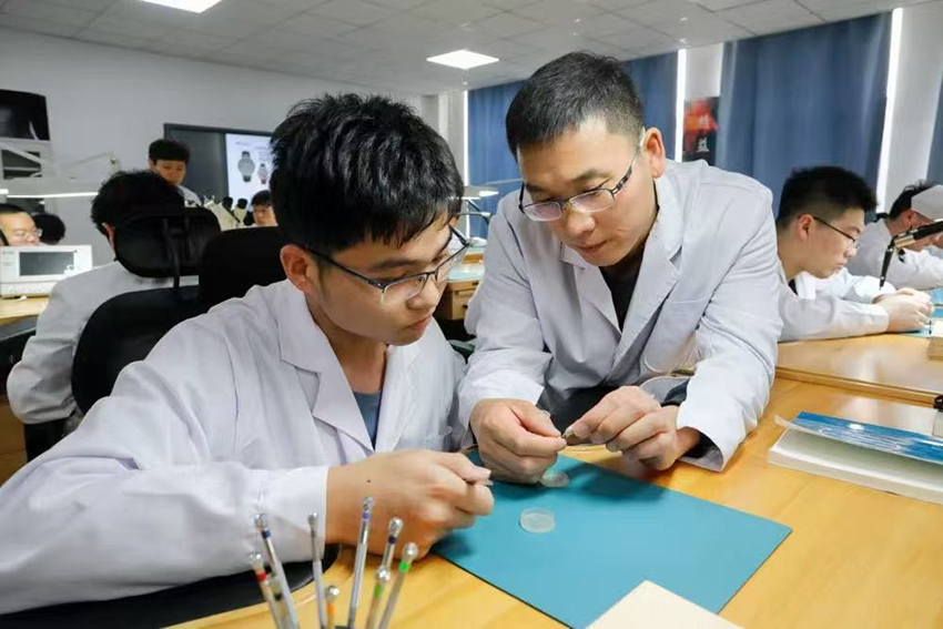 师生共同分析已装配完成的计时机芯工作状态。sunbet集团中国官网入口供图